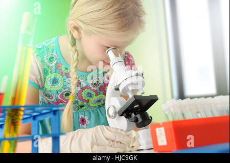 Girl pretending to be scientist looking through microscope Stock Photo