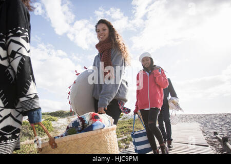 Young adult picnicking friends strolling along beach boardwalk, Western Cape, South Africa Stock Photo