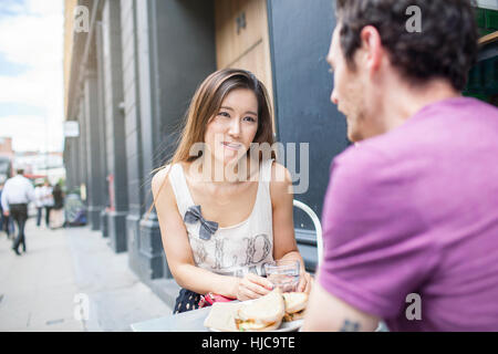 Mid adult couple having lunch at city sidewalk cafe Stock Photo