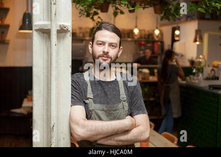 Portrait of young male cafe owner in cafe Stock Photo