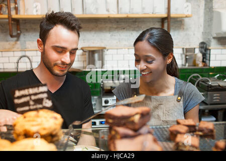 Waiter and waitress preparing food in cafe Stock Photo