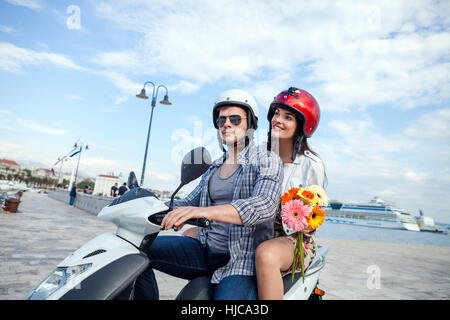 Young couple riding moped at harbour, Split, Dalmatia, Croatia Stock Photo