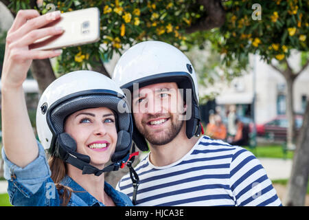 Young moped couple taking selfie in park, Split, Dalmatia, Croatia Stock Photo