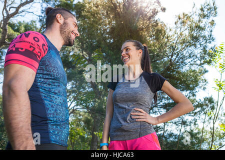 Male and female runners chatting in park, Split, Dalmatia, Croatia Stock Photo
