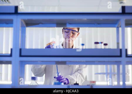 Scientist in laboratory using electronic pipette Stock Photo