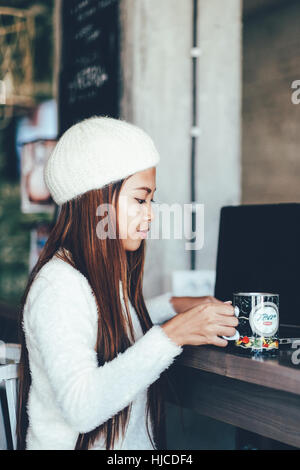 Pretty young asian woman drinking green fresh vegetable juice or ...