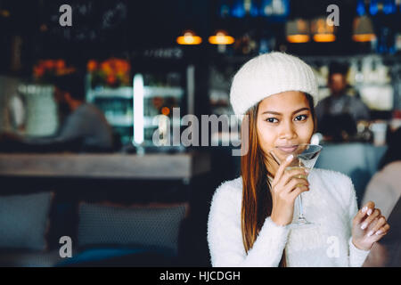 Beautiful girl drinking Martini in a bar Stock Photo