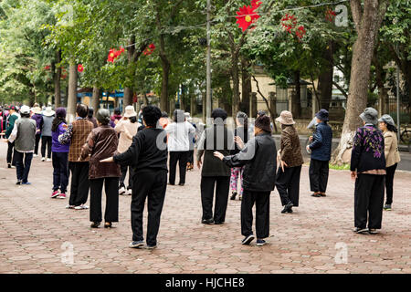 People doing morning group exercise near Hoan Kiem Lake, Hanoi, Vietnam Stock Photo