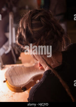 Woman violin maker, luthier, at work in her laboratory in Cremona, Italy Stock Photo