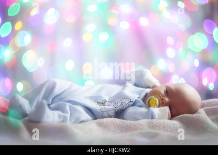 Cute newborn baby portrait on magic lights bokeh background Stock Photo