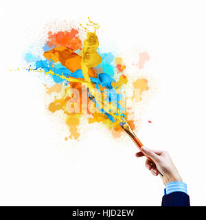 Background image with human hand holding paint brush Stock Photo