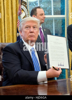 Washington, Us. 23rd Jan, 2017. United States President Donald Trump shows the Executive Order titled 'Mexico City' which bans federal funding of abortions overseas after signing it in the Oval Office of the White House in Washington, DC on Monday, January 23, 2017. The other two Executive Orders concerned withdrawing the US from the Trans-Pacific Partnership (TPP) and a US Government hiring freeze for all departments but the military. Credit: Ron Sachs/Pool via CNP - NO WIRE SERVICE- Photo: Ron Sachs/Consolidated News Photos/Ron Sachs - Pool via CNP/dpa/Alamy Live News Stock Photo