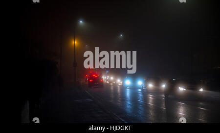 Morden, London, UK. 25th Jan, 2017. Vehicles passing through Morden early in the morning rush hour with traffic headlights shining in thick fog. Credit: Malcolm Park editorial/Alamy Live News Stock Photo