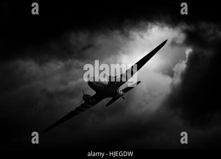 dakota plane flying between the dark storm clouds Stock Photo