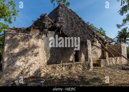 Medieval primitive large house with straw roof,built by native local people, made out of wooden sticks, dead coral, and red soil (no bricks), Zanzibar Stock Photo