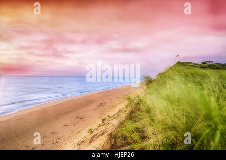 A pastel, pink sunrise over a beach on Cape Cod. Stock Photo