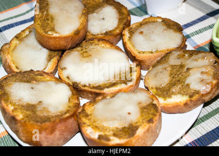 Slices of toasted bread season with olive paste and melted cheese Stock Photo