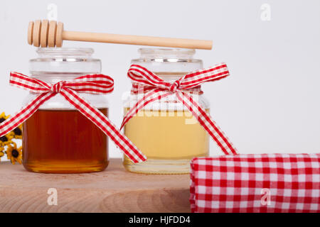 Honey in  jar with honey dipper on a light background, selective focus and small depth of field Stock Photo