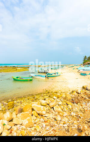 A local fishing village with anchored fishermen's boats on the beach is seen along the northern coast in Jaffna. Vertical Stock Photo