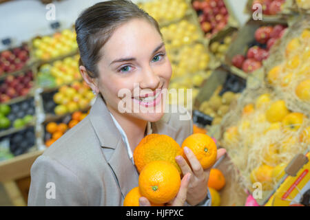 pretty woman buying fresh fruits and vegetables at food-store Stock Photo