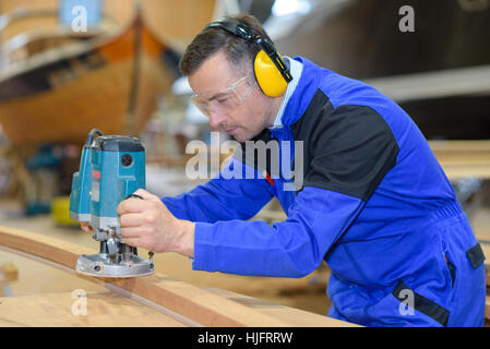 Carpenter using electric sander Stock Photo