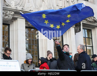 A man waves a flag outside the Supreme Court in London where Britain's most senior judges will rule if Theresa May has the power to trigger the formal process for the UK's exit from the European Union. Stock Photo