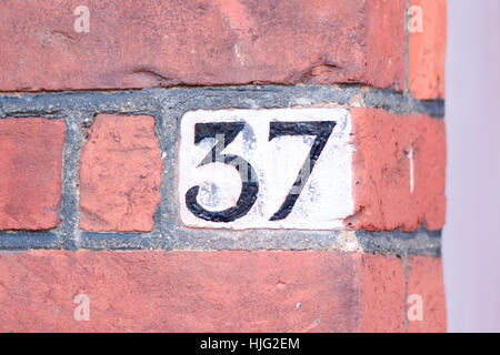 House number 37 sign painted black on white background on wall Stock Photo