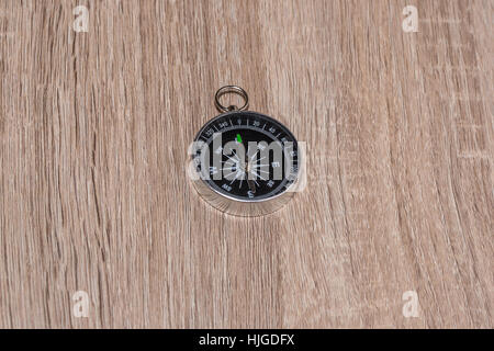 A compass point to North on the wooden table. Stock Photo