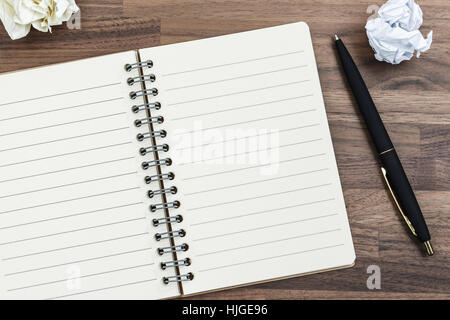 Notebook on office wood desk with pen and crumpled paper ball Stock Photo