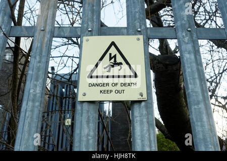 danger of death keep out electricity sign and fence Stock Photo