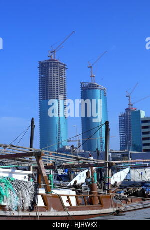 Villamar high-rise residential towers, part of the Financial Harbour project, with fishing dhows in front, Bahrain Stock Photo