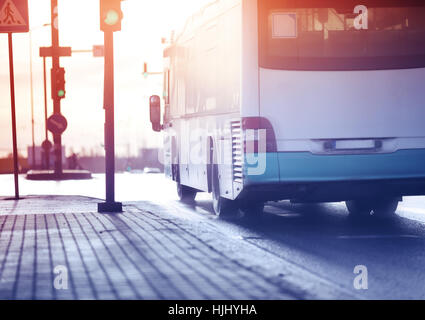 Bus moving on the road in city in early morning Stock Photo