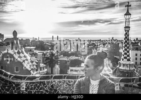 Barcelona signature style. elegant woman in coat at Guell Park in Barcelona, Spain looking aside Stock Photo