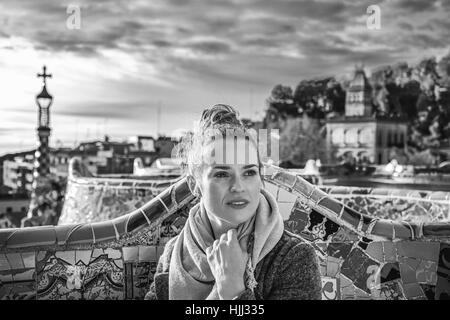 Barcelona signature style. young tourist woman in coat at Guell Park in Barcelona, Spain looking into the distance Stock Photo