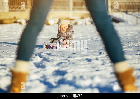 Little girl sitting in the snow Stock Photo