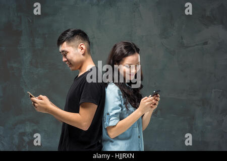 Asian young couple using cellphone, closeup portrait. Stock Photo