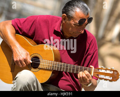 busker playing classical Spanish guitar in the square in front of Cadiz Cathedral Spain.