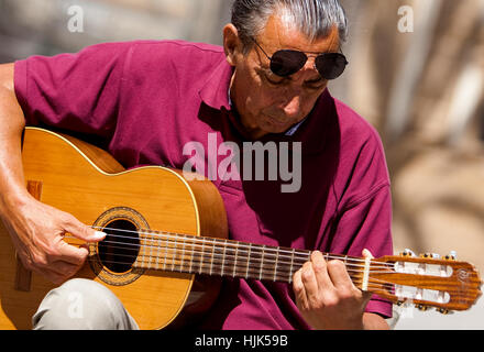 busker playing classical Spanish guitar in the square in front of Cadiz Cathedral Spain
