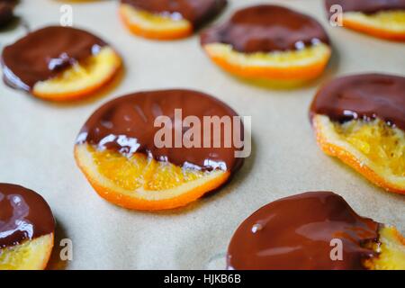 Making candied orange slices dipped in dark chocolate Stock Photo