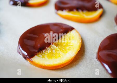 Making candied orange slices dipped in dark chocolate Stock Photo