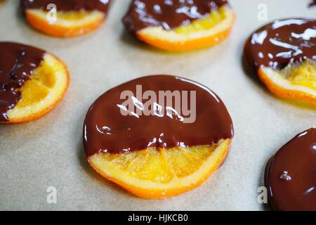 Making candied orange slices dipped in dark chocolate Stock Photo
