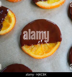 Making candied orange slices dipped in dark chocolate Stock Photo