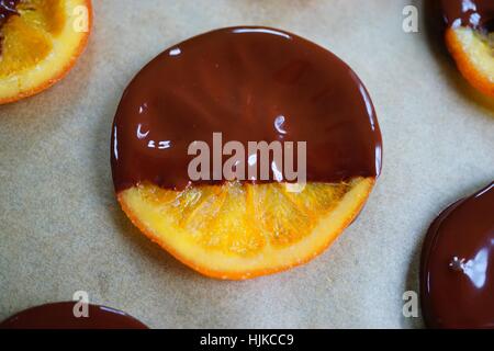 Making candied orange slices dipped in dark chocolate Stock Photo