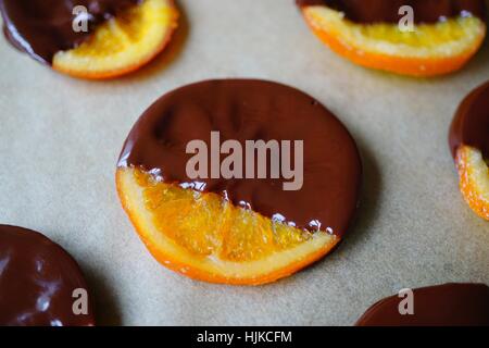 Making candied orange slices dipped in dark chocolate Stock Photo