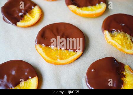 Making candied orange slices dipped in dark chocolate Stock Photo
