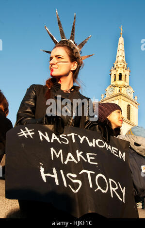 Women's march against Trump. A woman with a beaten up face wears a Statue of Liberty head-dress and holds a Nasty Women banner Stock Photo