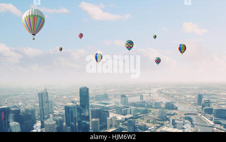 Colorful aerostats flying in clear sky above modern city Stock Photo ...