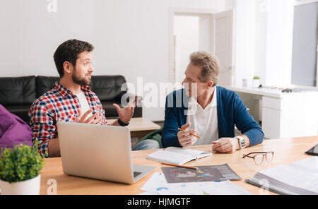 Nice male colleagues discussing work issues Stock Photo