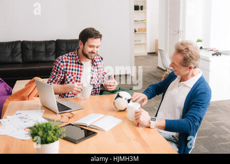 Delighted positive men having tea Stock Photo