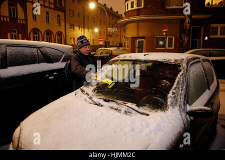 Man cleaning snow car hood with scraper Stock Photo